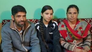 Bhawna, 12th class topper and daughter of Ghanahatti Panchayat, sitting with her parents.