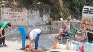 People filling water from hand pumps